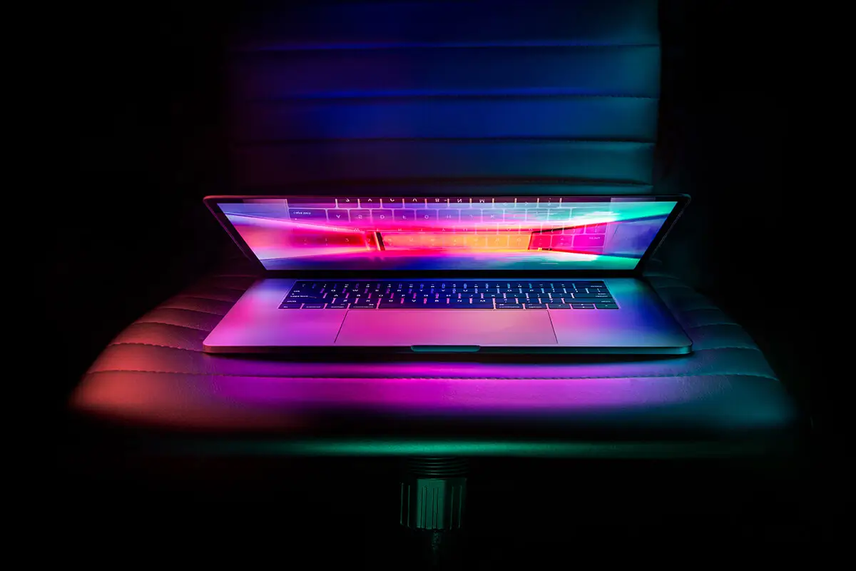 Partially open laptop glowing with neon light